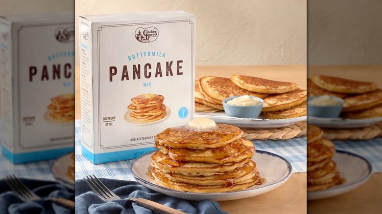 Plates of pancakes set beside a box of Cracker Barrel Buttermilk Pancake Mix