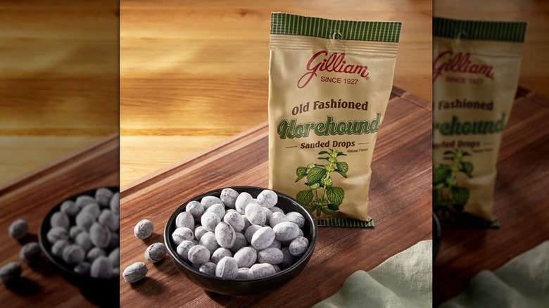 Package of Gilliam sanded drops beside a bowlful atop a wooden board