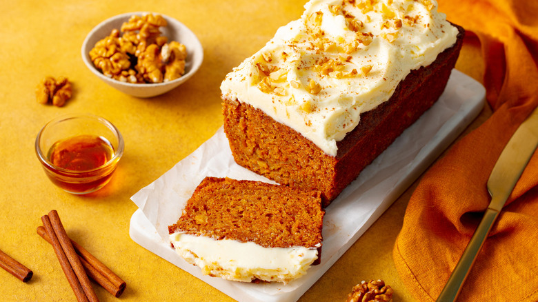 Loaf of carrot cake topped with maple-cinnamon cream cheese