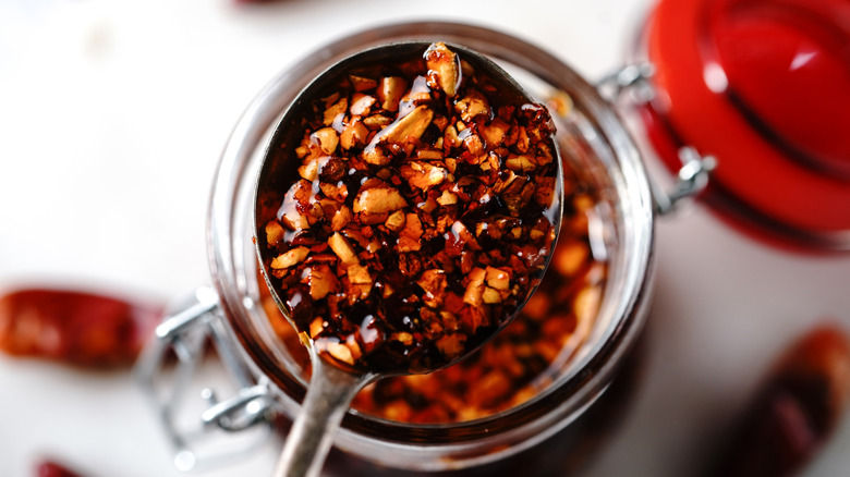 Spoonful of chili crisp over homemade jar of the condiment