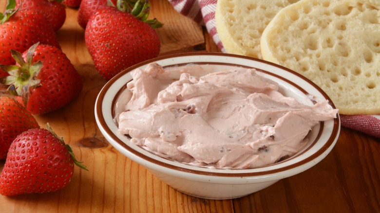 Bowl of strawberry cream cheese with fresh berries alongside