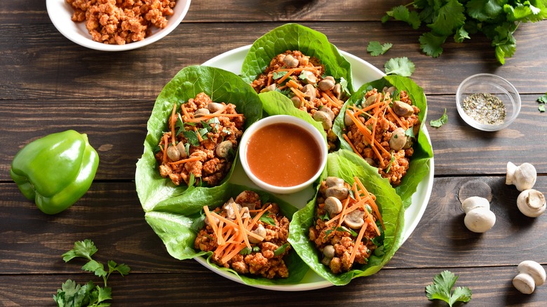 Minced meat lettuce wraps with shaved carrots and cilantro