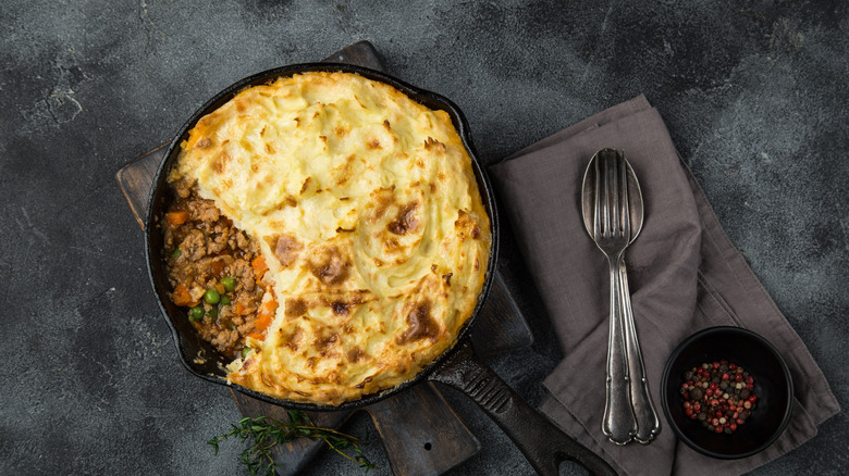 Shepherd's pie in a skillet next to silverware