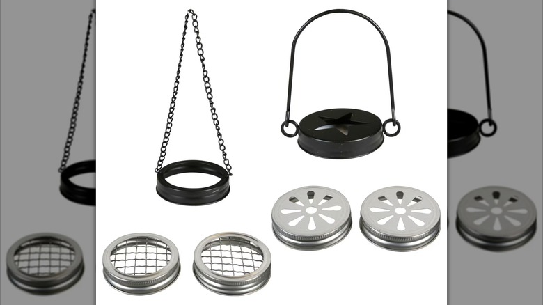An assortment of jar lids -- two black ones with hanging handles, and two sets of silver lids with decorative tops