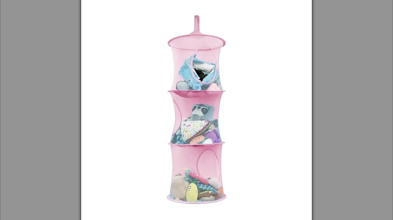 A three-tiered, hanging mesh storage cubby holding toys