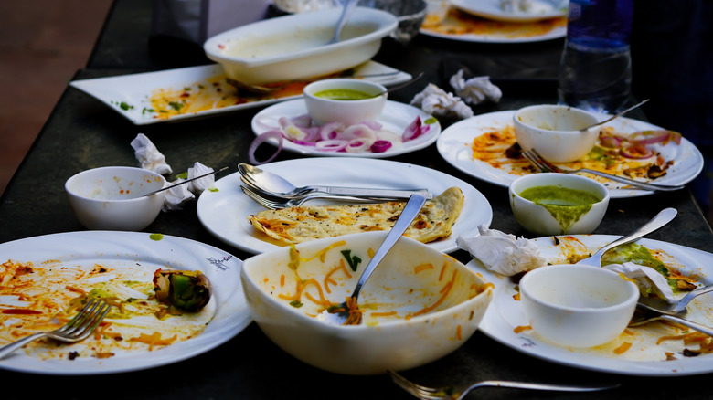 A restaurant table filled with dirty plates