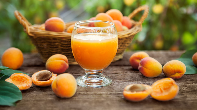 Apricot juice surrounded by apricots.