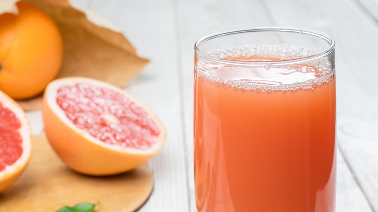Grapefruit juice alongside grapefruit.