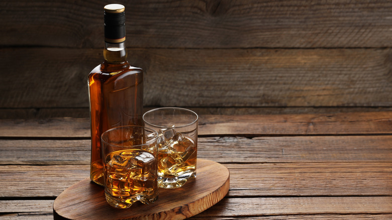 A bottle and glasses of bourbon.