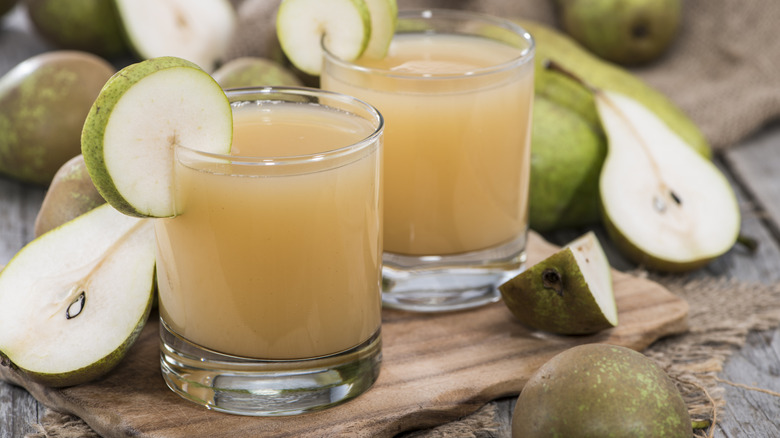 Pear juice surrounded by pears.