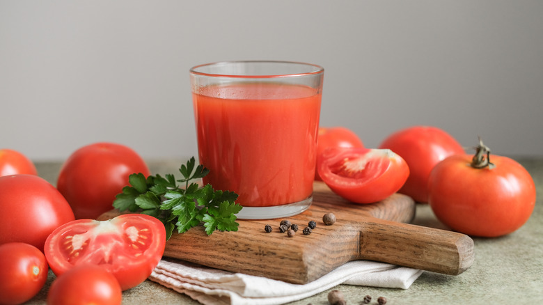 Tomato juice surrounded by tomatoes.