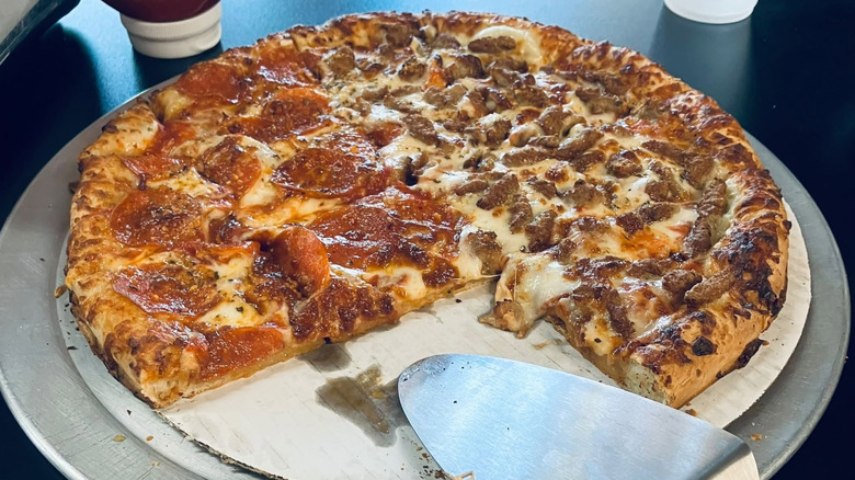 Half pepperoni half Italian sausage pizza from Hunt Brothers Pizza sitting on a plate.