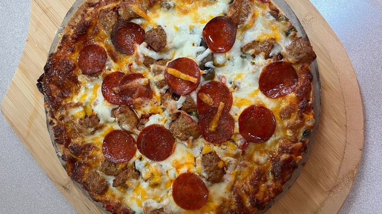 Cooked Pothole Kitchen Sink pizza from Kwik Trip on a pizza board.