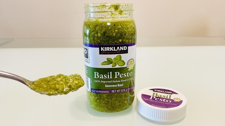 Open jar and spoonful of Kirkland Signature Basil Pesto