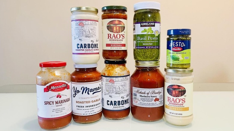 Various store-bought pasta sauce jars stacked on table
