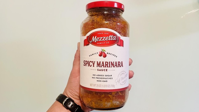 Hand holding jar of Mezzetta Family Recipe Spicy Marinara Sauce