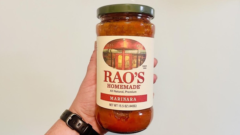 Hand holding jar of Rao's Homemade Marinara Sauce