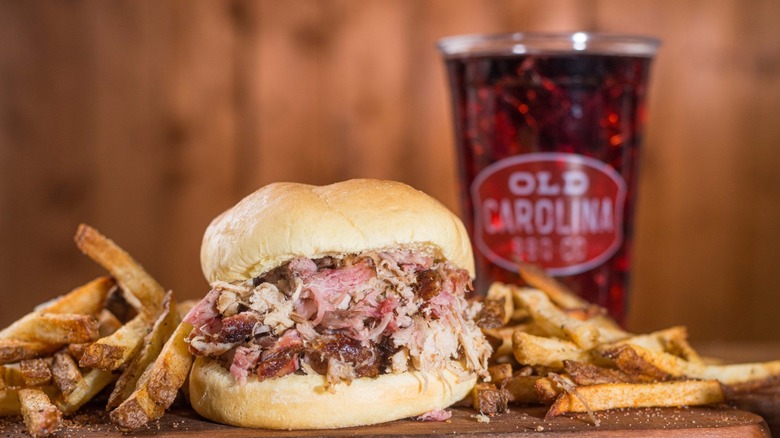 Pulled meat in a bun with fries and a soda
