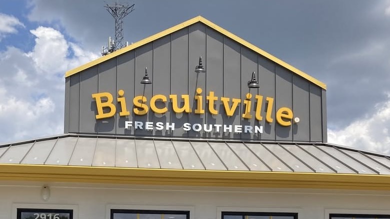 Yellow Biscuitville sign on a gray-paneled building