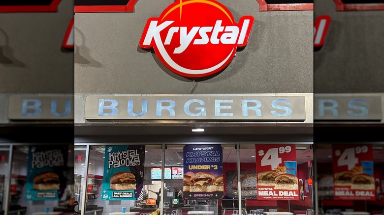 Red, white, and yellow Krystal logo on a stone building with a sign that reads "BURGERS" underneath
