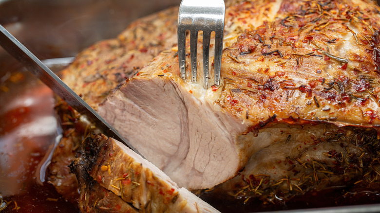 A pork roast is being sliced