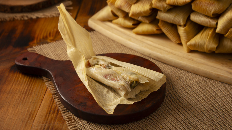 Unwrapped tamale on a wooden platter