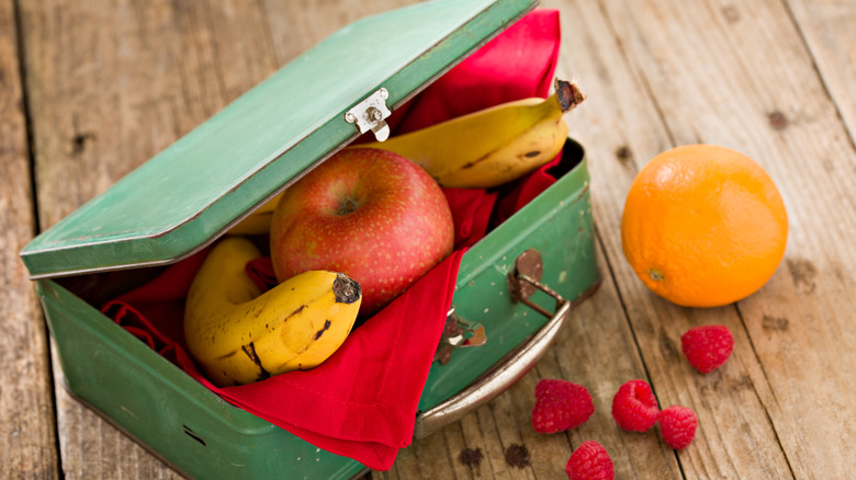 Green metal lunch box filled with produce