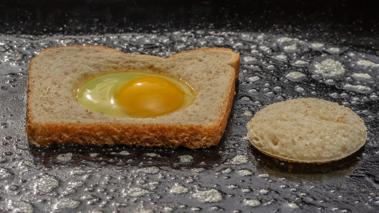 The surface of a Blackstone Griddle is covered with oil and an egg in toast