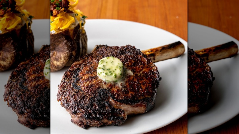 A bone-in ribeye topped with butter at Stoney River Steakhouse and Grill