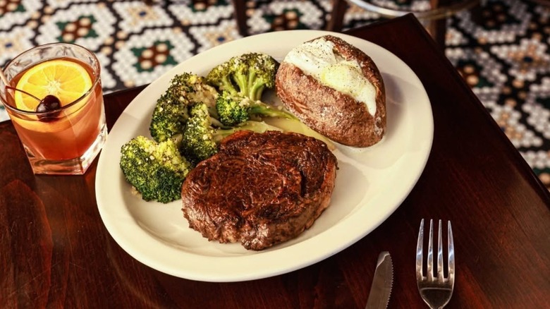 The Bison Delmonico Ribeye at Ted's Montana Grill, plated with broccoli and a baked potato