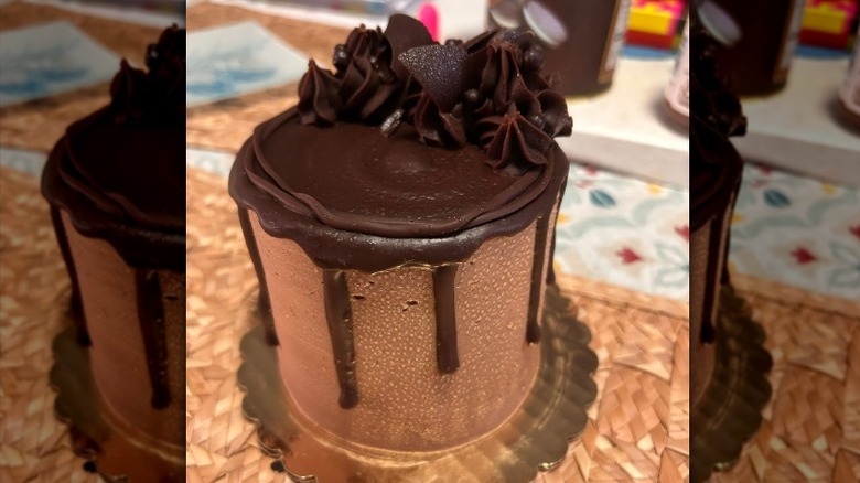 A Whole Foods Chocolate Eruption Cake sits on a woven straw mat