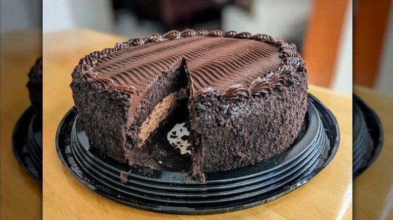 A Kirkland Chocolate Cake with Chocolate Mousse Filling from Costco sits on a wooden table