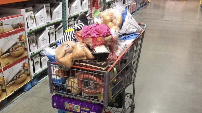 A cart piled high with merchandise abandoned in the aisle of a Costco