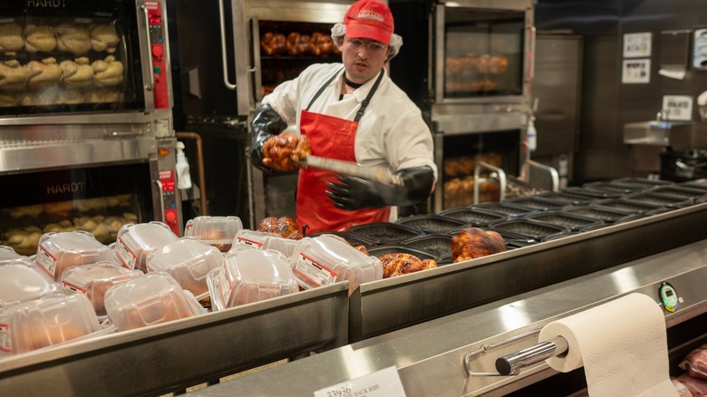 Costco employee packaging fresh rotisserie chickens