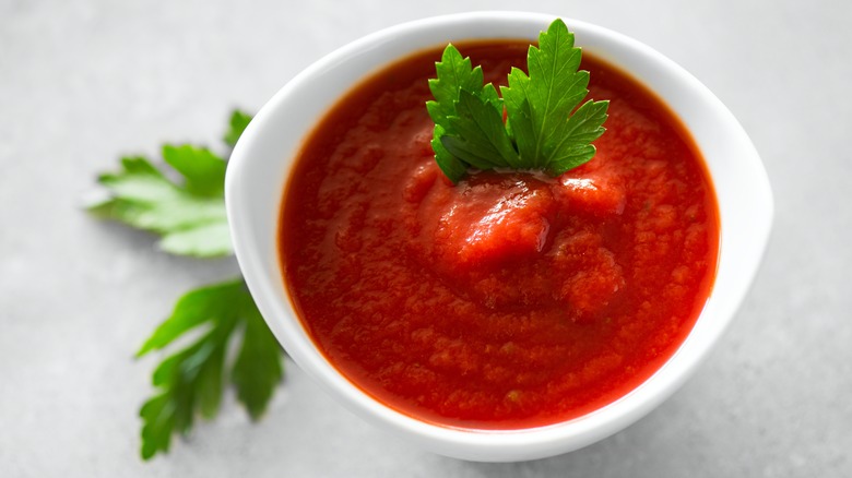 bowl of red pasta sauce with herb garnish