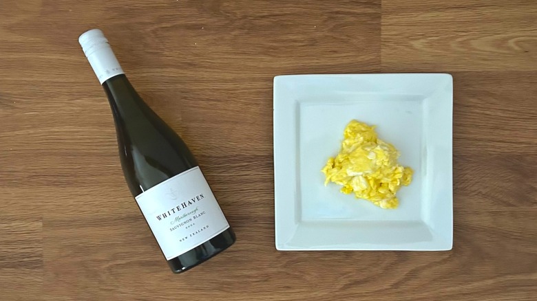 Bottle of Whitehaven Sauvignon Blanc and square white plate of scrambled eggs