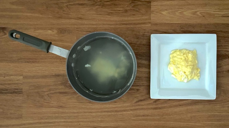 Pot of boiling water and square white plate of scrambled eggs