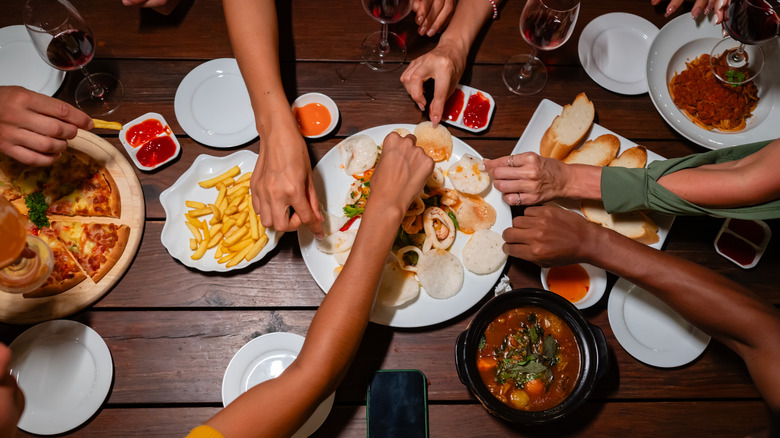 Friends share plates at a restaurant.