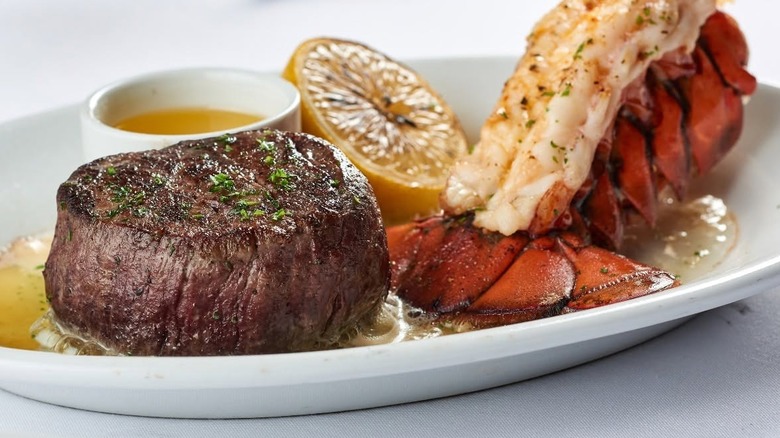 Steak and lobster sit on a platter.