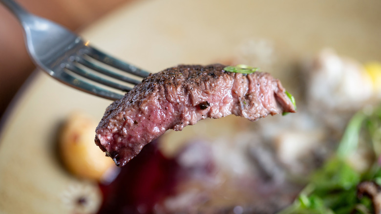 A piece of steak on a fork.