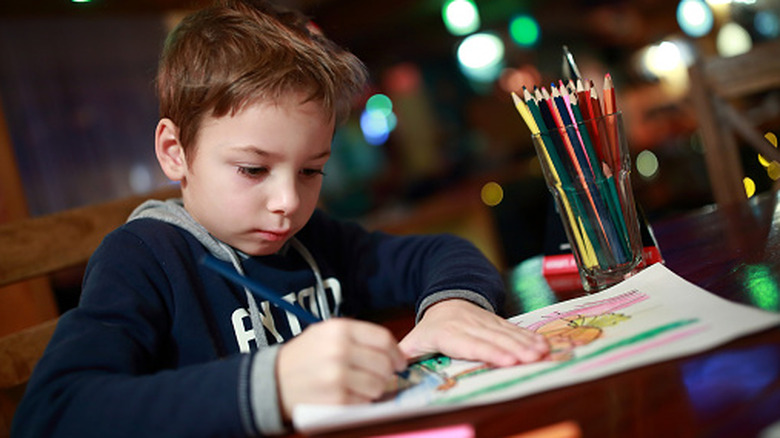 A child drawing at a restaurant.