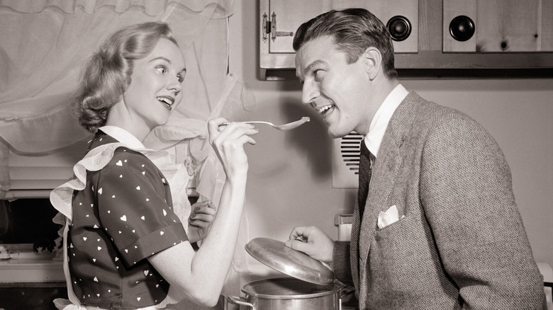 1950s housewife feeding husband with spoon