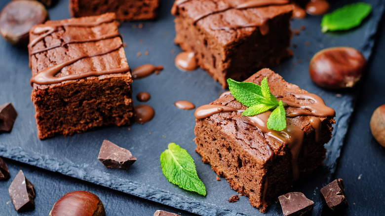 Brownies on a slate with mint and chocolate pieces