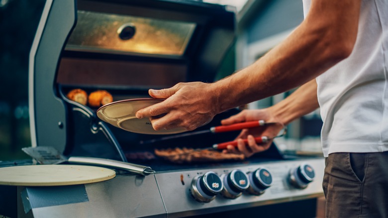 Cook adding steak to grill