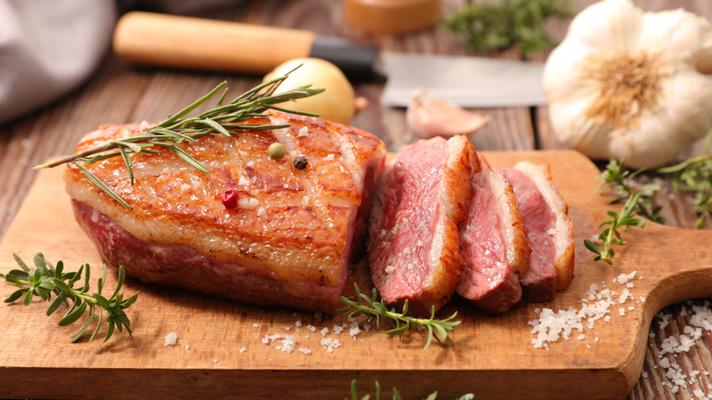 Cooked sliced duck breast on cutting board