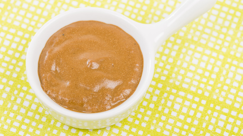 Creole mustard in white bowl on yellow tablecloth