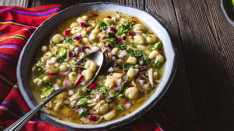 White posole with garnishes on a wooden table