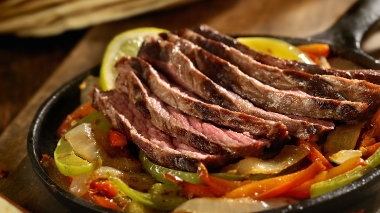 Grilled skirt steak and vegetables on iron skillet
