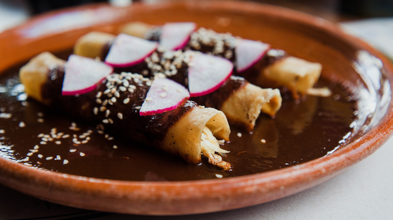 Enchiladas with black mole sauce