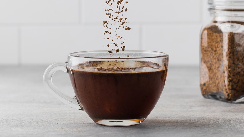 instant coffee dropping into a coffee mug